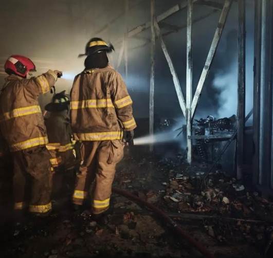 Efectivos del Cuerpo de Bomberos de Maracaibo sofocando incendio en estructura industrial de madrugada