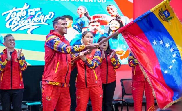 Atletas venezolanos Dennis Pérez y Dakota Ferrer recibiendo la bandera nacional antes de viajar a Panamá