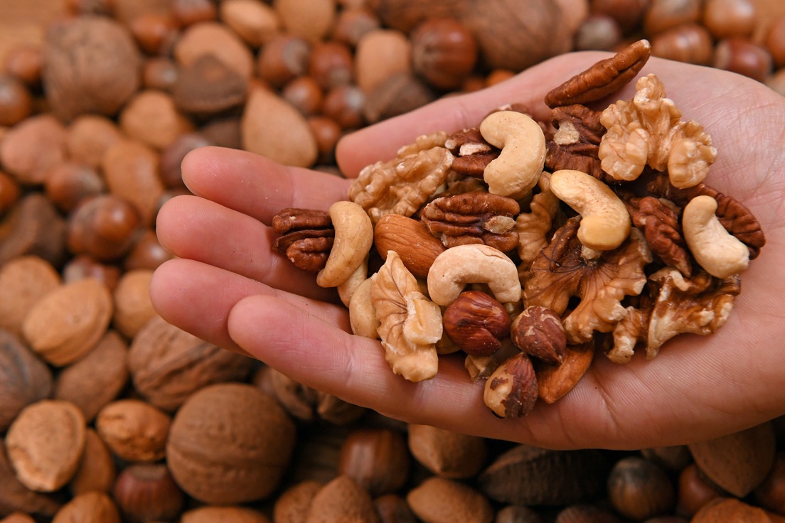 Imagen ilustrativa de frutos secos variados incluyendo nueces, almendras y maní